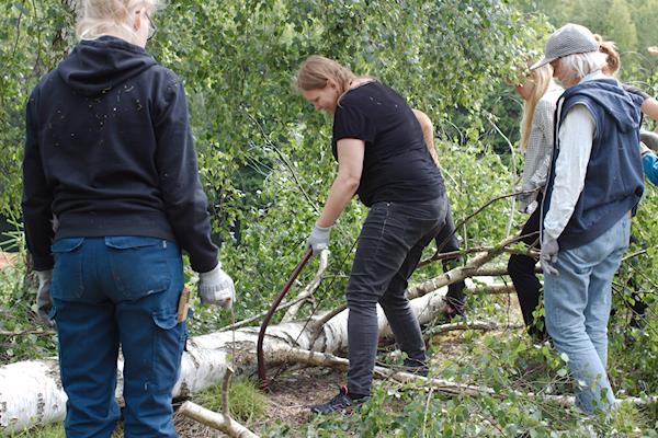 Kursdeltagare arbetar med bågsåg