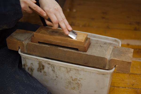 Chisel being sharpened on a waterstone